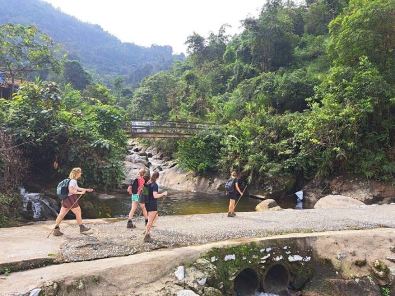 Randonneurs traversant les dalles rocheuses d’un torrent, Tay Con Linh, Ha Giang