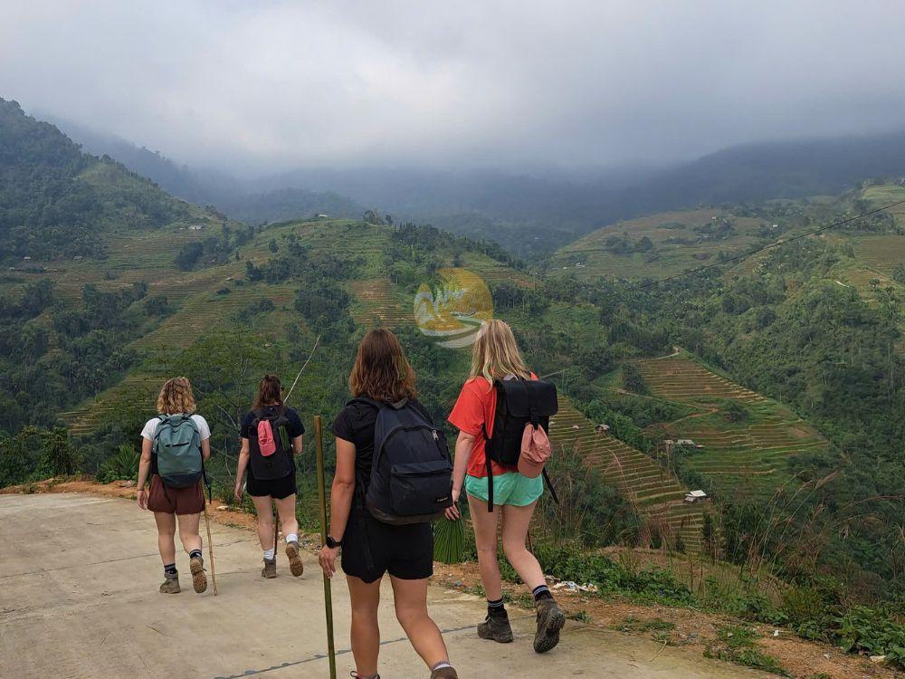 Hikers walking on a mountain trail during a 2-day Tay Con Linh trekking tour in Ha Giang