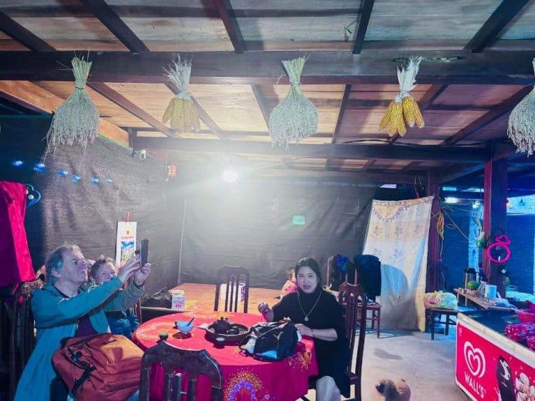 Visitors enjoying a meal and conversation inside a Dao Ao Dai Villages homestay