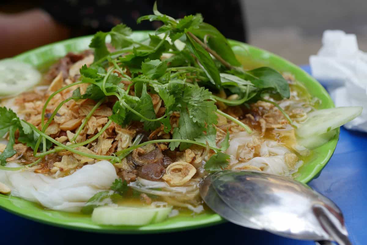 Steamed rice rolls Banh Cuon served floating in hot pork bone broth in Ha Giang