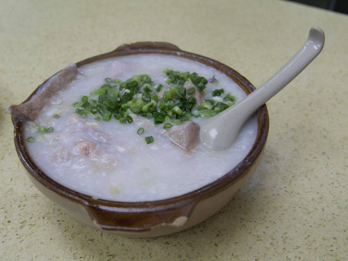 Hot bowl of medicinal Chao Au Tau aconite night porridge topped with minced pork and herbs in Ha Giang
