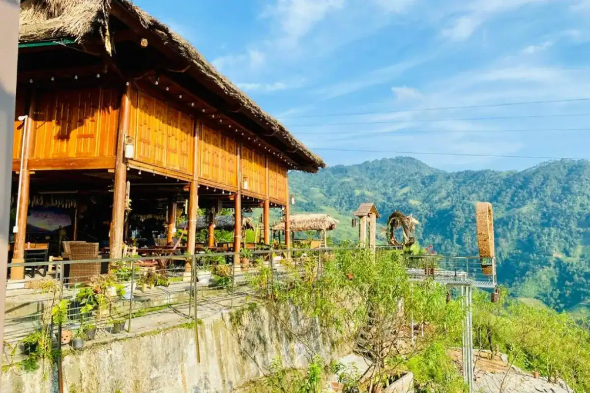Scenic wooden stilt terrace overlooking lush green mountain valleys and rice terraces in Khuoi My Ha Giang