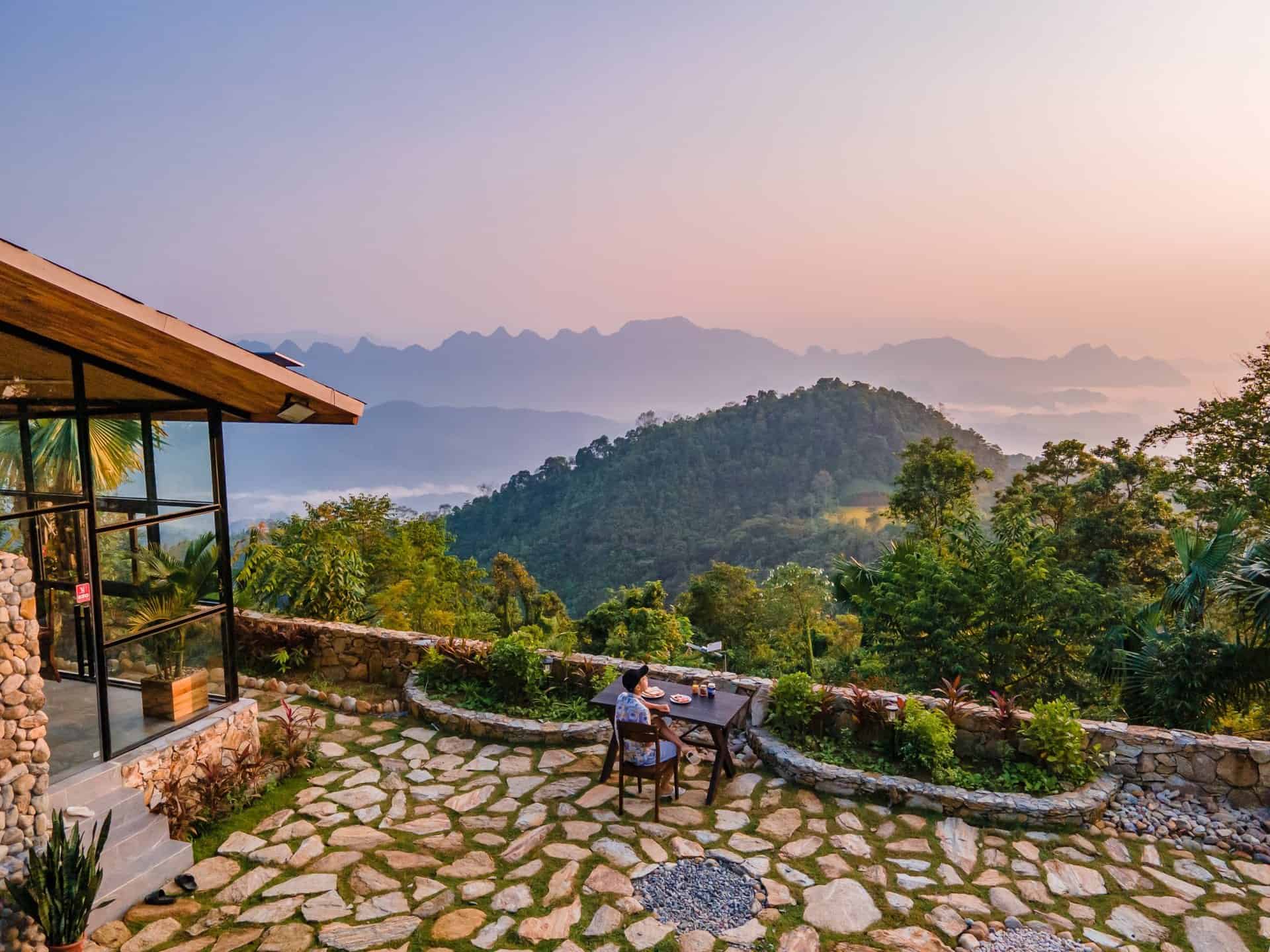 Phòng nghỉ TVPalm Ecolodge Hà Giang 10 Du khách ăn sáng ở sân đá nhìn ra dãy núi lúc bình minh tại TVPalm Ecolodge