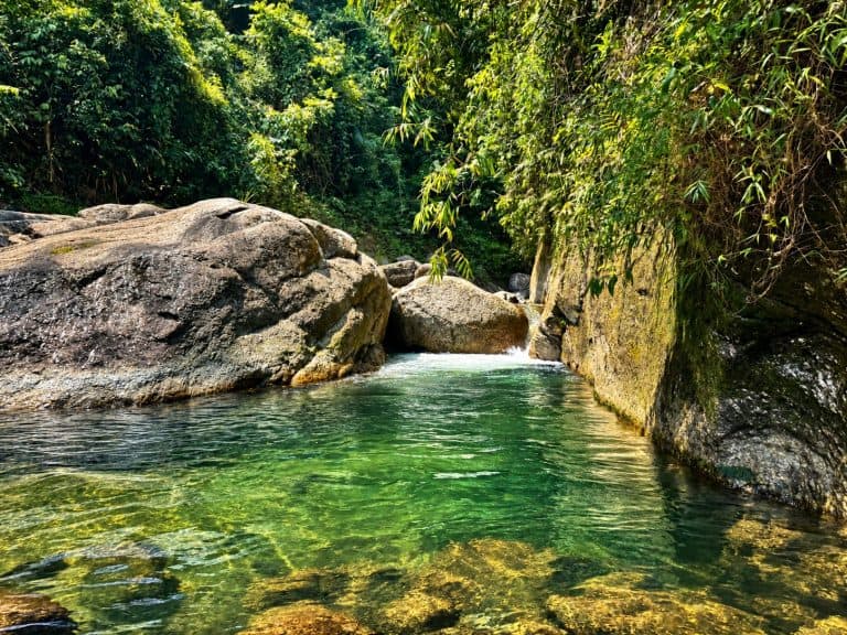 Clear green stream pool between boulders near Khuoi My