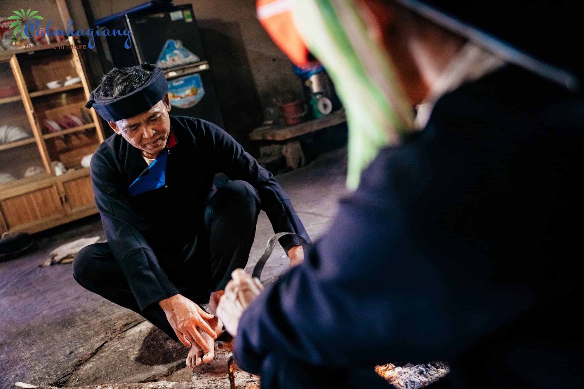 Les Dao Ao Dai du Tay Con Linh : guide de leur culture 6 Un ancien dao Ao Dai en tunique indigo noire et turban, assis près du foyer
