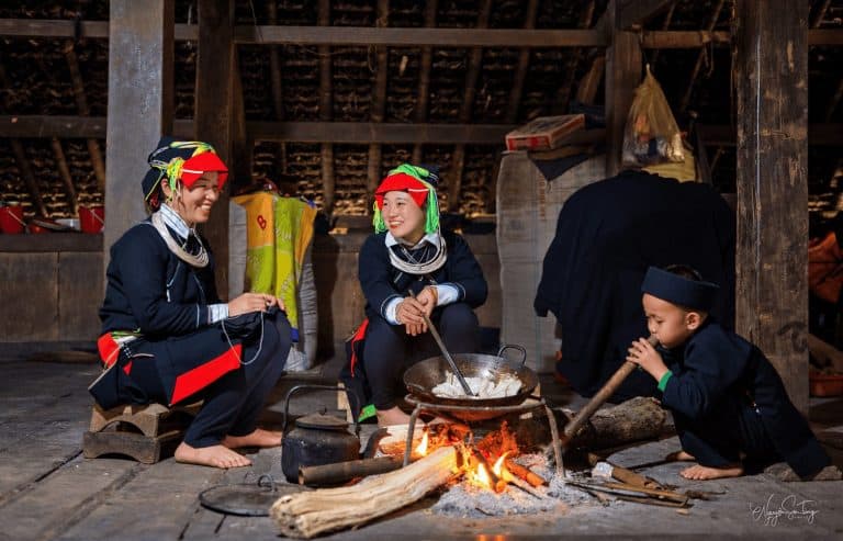 Dao Ao Dai family by the kitchen fire in their wooden house