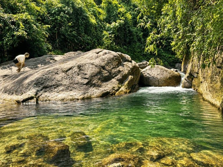 A clear forest stream and rock pool near Tay Con Linh