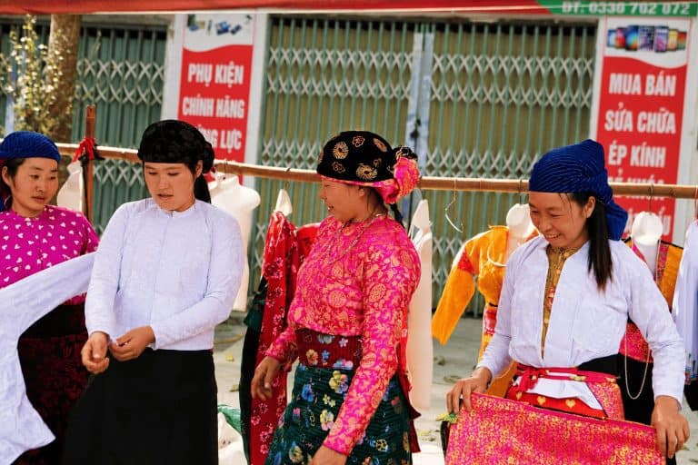 Hmong women choosing traditional clothes at a highland market