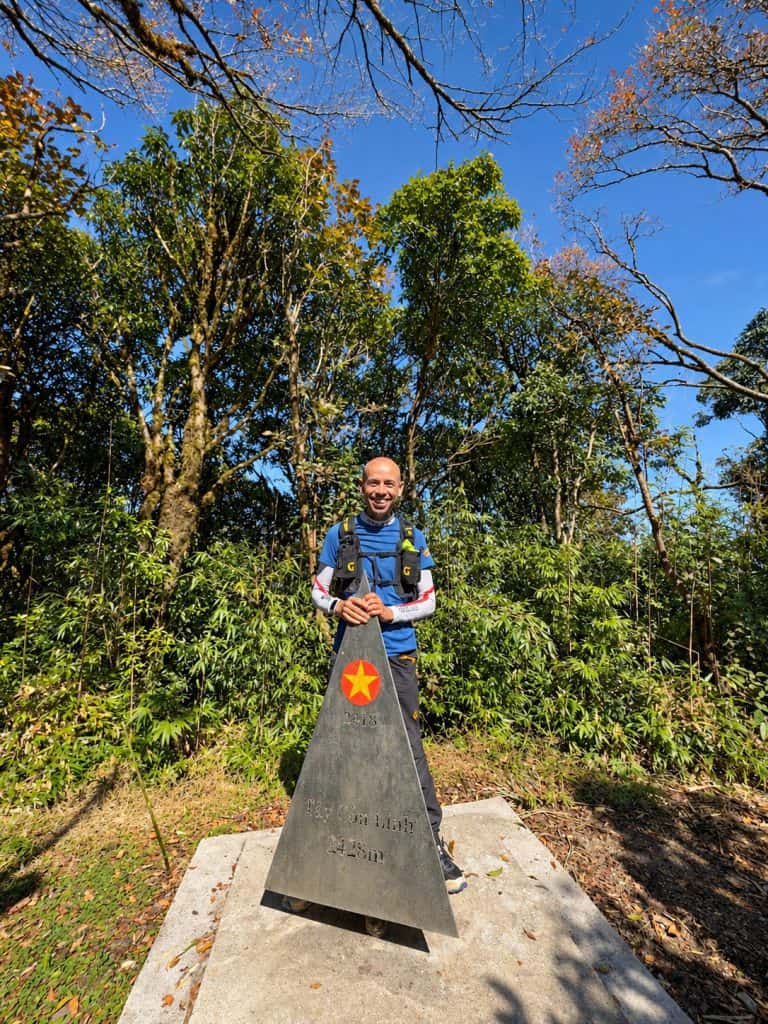 Trekker at the Tay Con Linh summit marker, 2,428 m