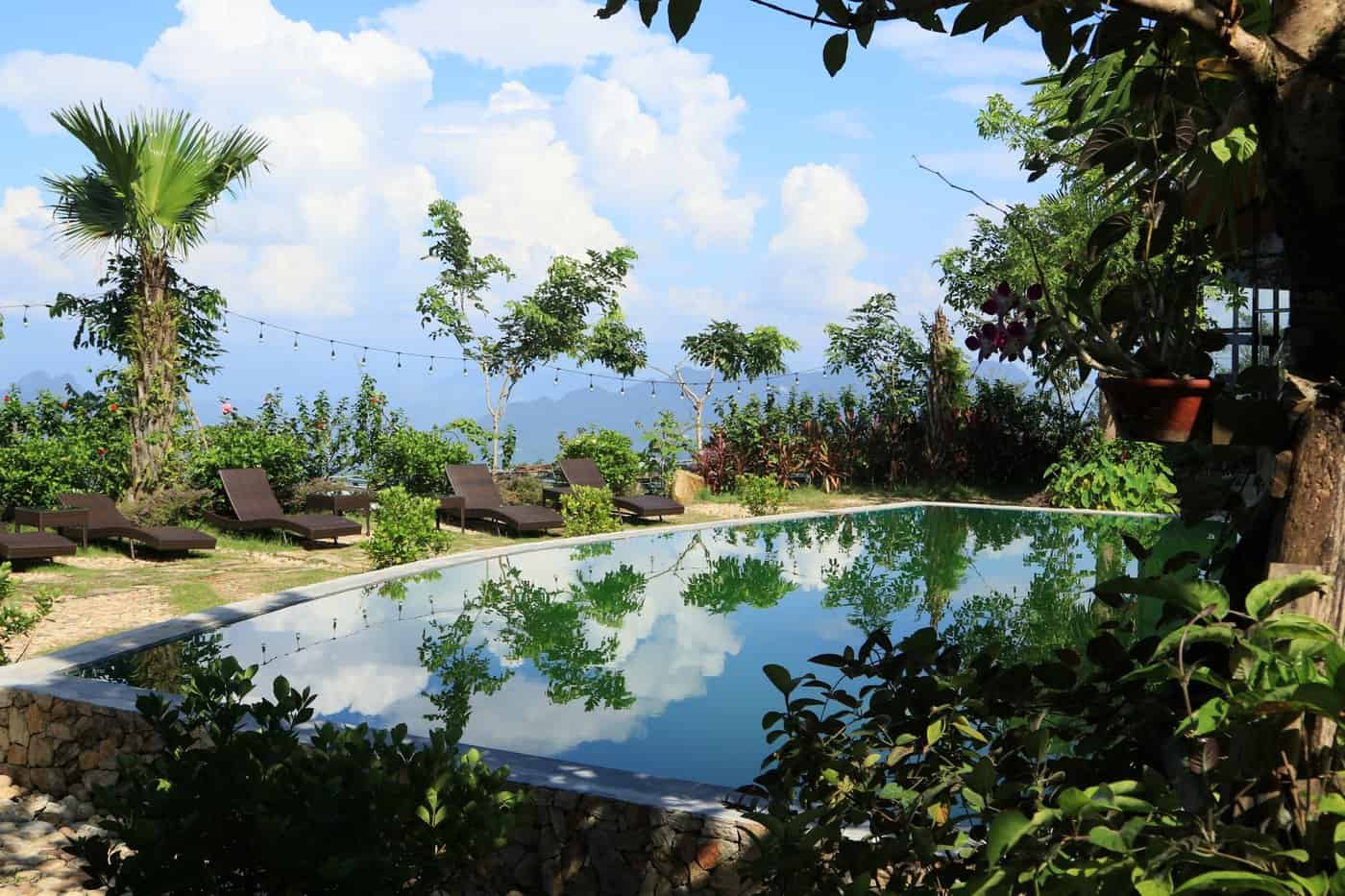 Phòng nghỉ TVPalm Ecolodge Hà Giang 17 Bể bơi TVPalm Ecolodge với ghế nghỉ bên bờ, nhìn ra núi và mây
