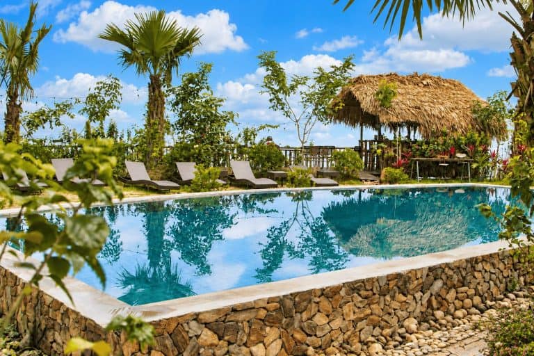 The swimming pool at TVPalm Ecolodge with the thatched bar
