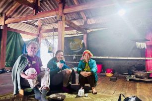 Travelers taking a rest stop inside a traditional Dao Ao Dai Villages stilt house