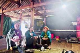 Travelers taking a rest stop inside a traditional Dao Ao Dai Villages stilt house